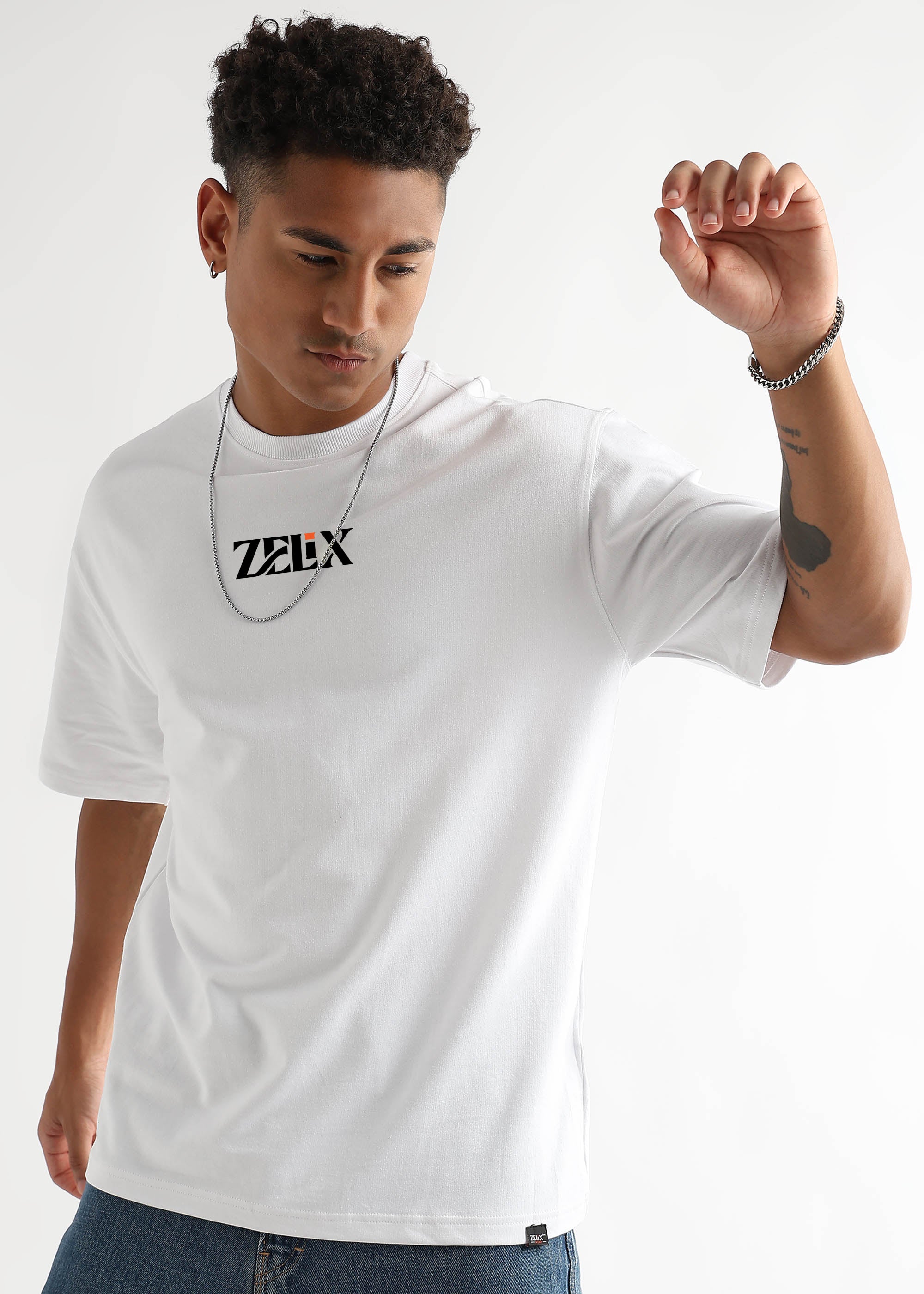 Man wearing a white t-shirt with 'Zelix' logo on a plain background