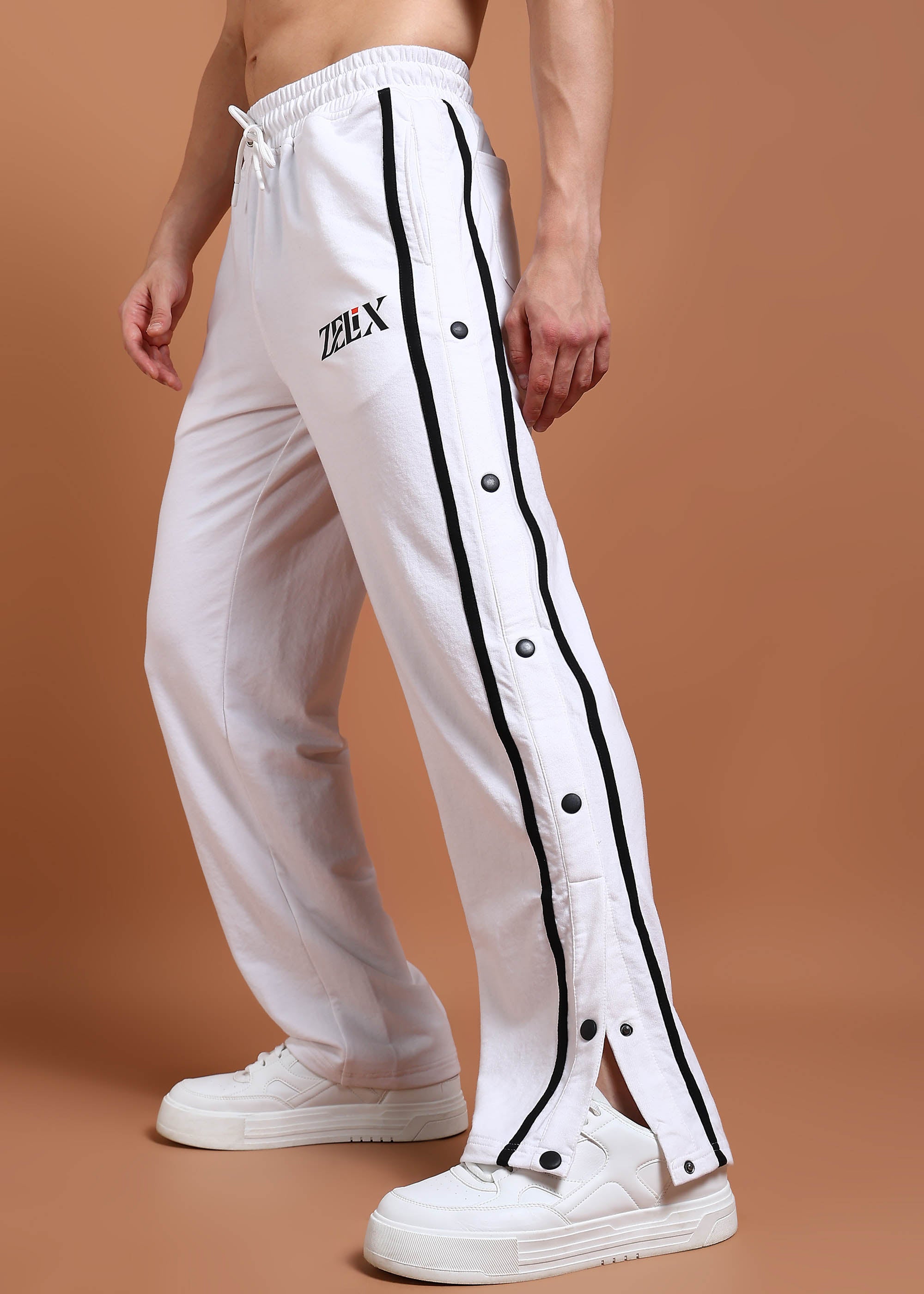 A person wearing white joggers with black contrast panels and a drawstring waist.