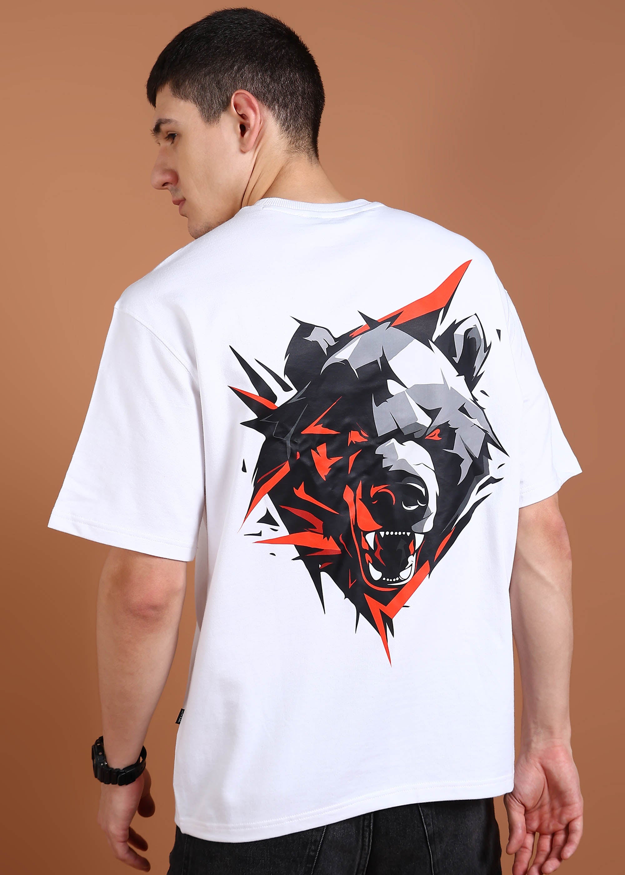 A person wearing a white oversized t-shirt with a geometric bear graphic on the back.