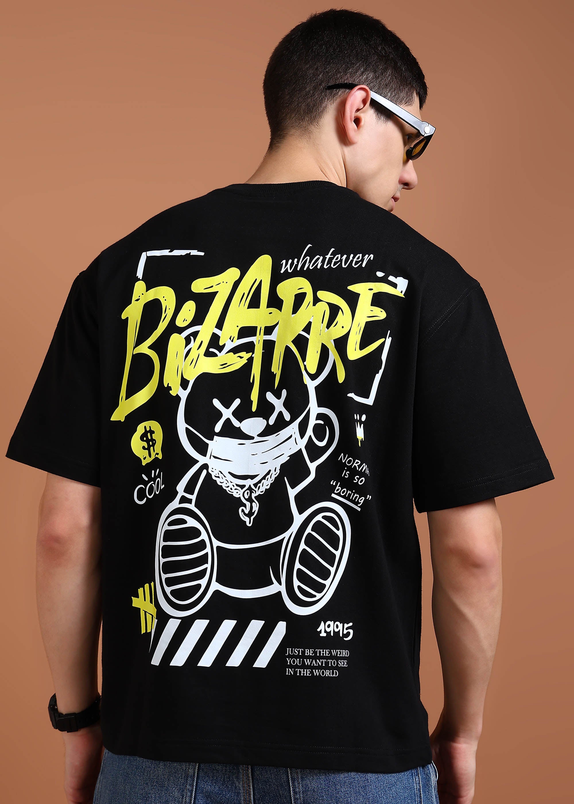 A person wearing an oversized black t-shirt with a graphic print of a bear and text on the back.