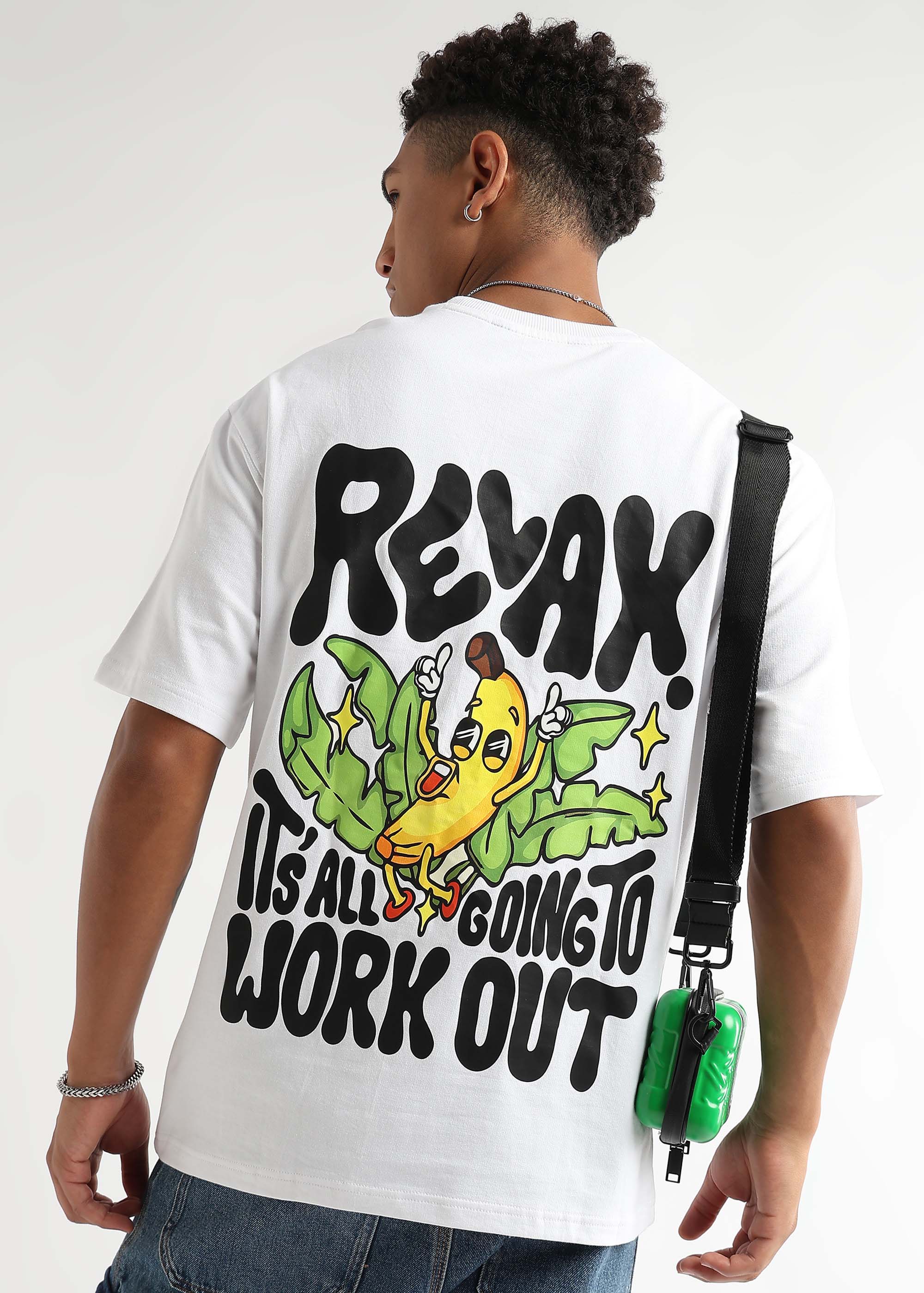 A person wearing a white oversized t-shirt with a banana graphic and text on the back.