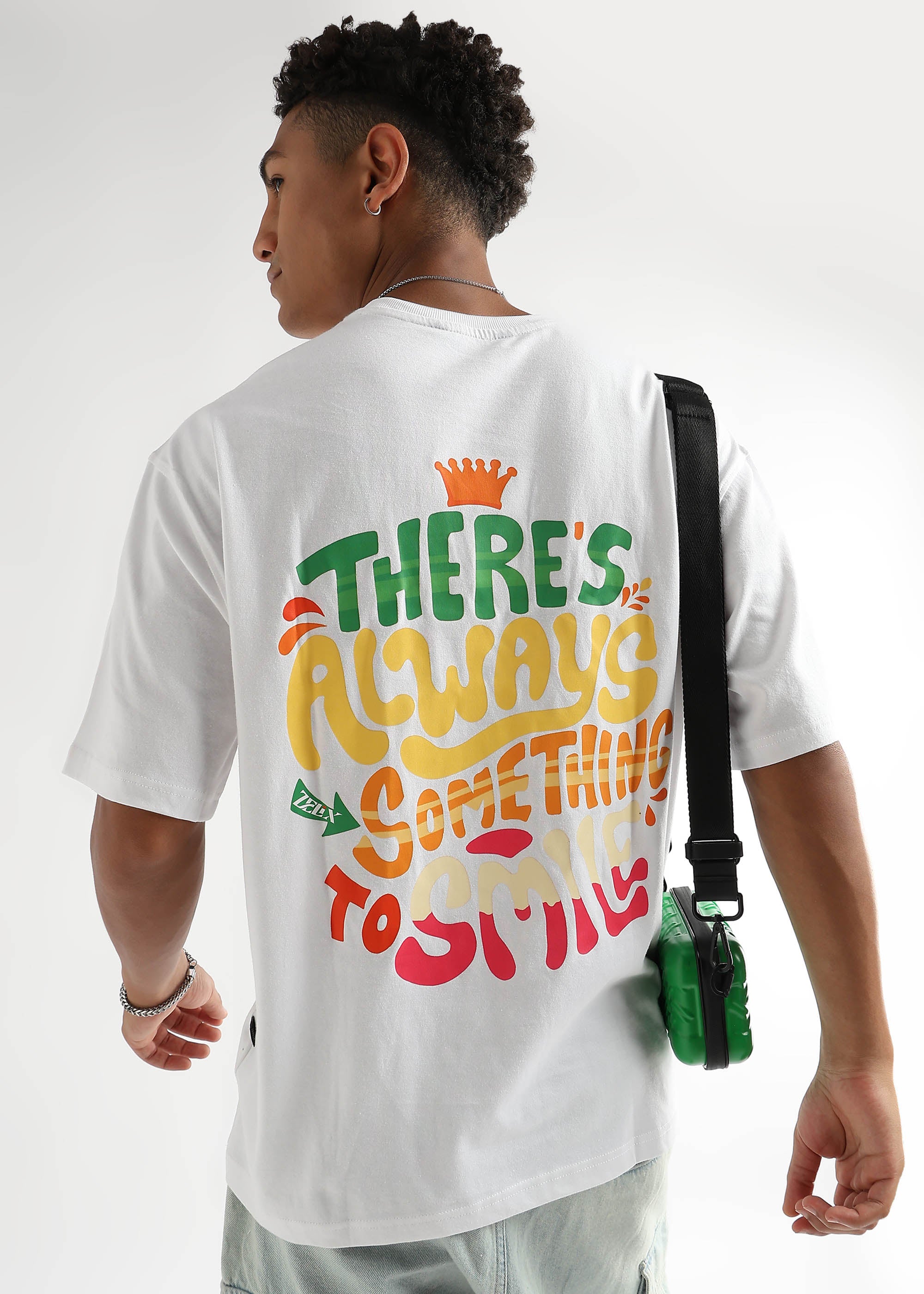 A person wearing an over-sized white T-shirt with colorful text on the back