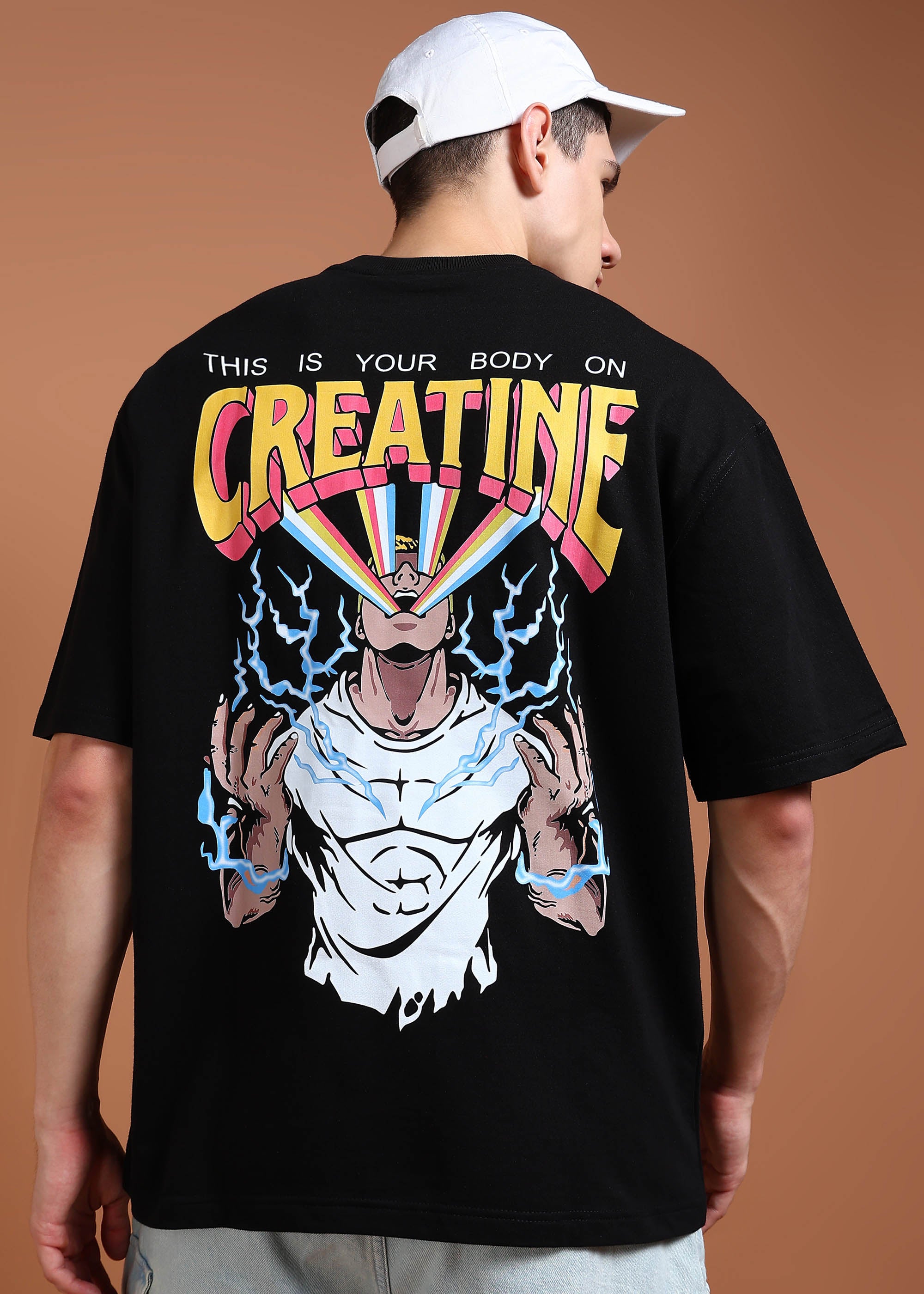 A person wearing an oversized black t-shirt with a graphic print on the back depicting a muscular character and the text 'CREATINE'.