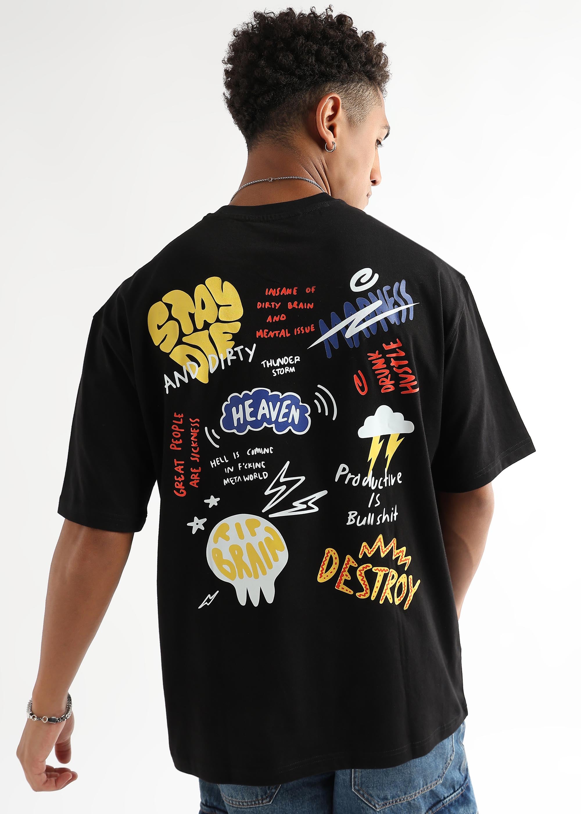 A person wearing an oversized black t-shirt with colorful text and graphic prints on the back.