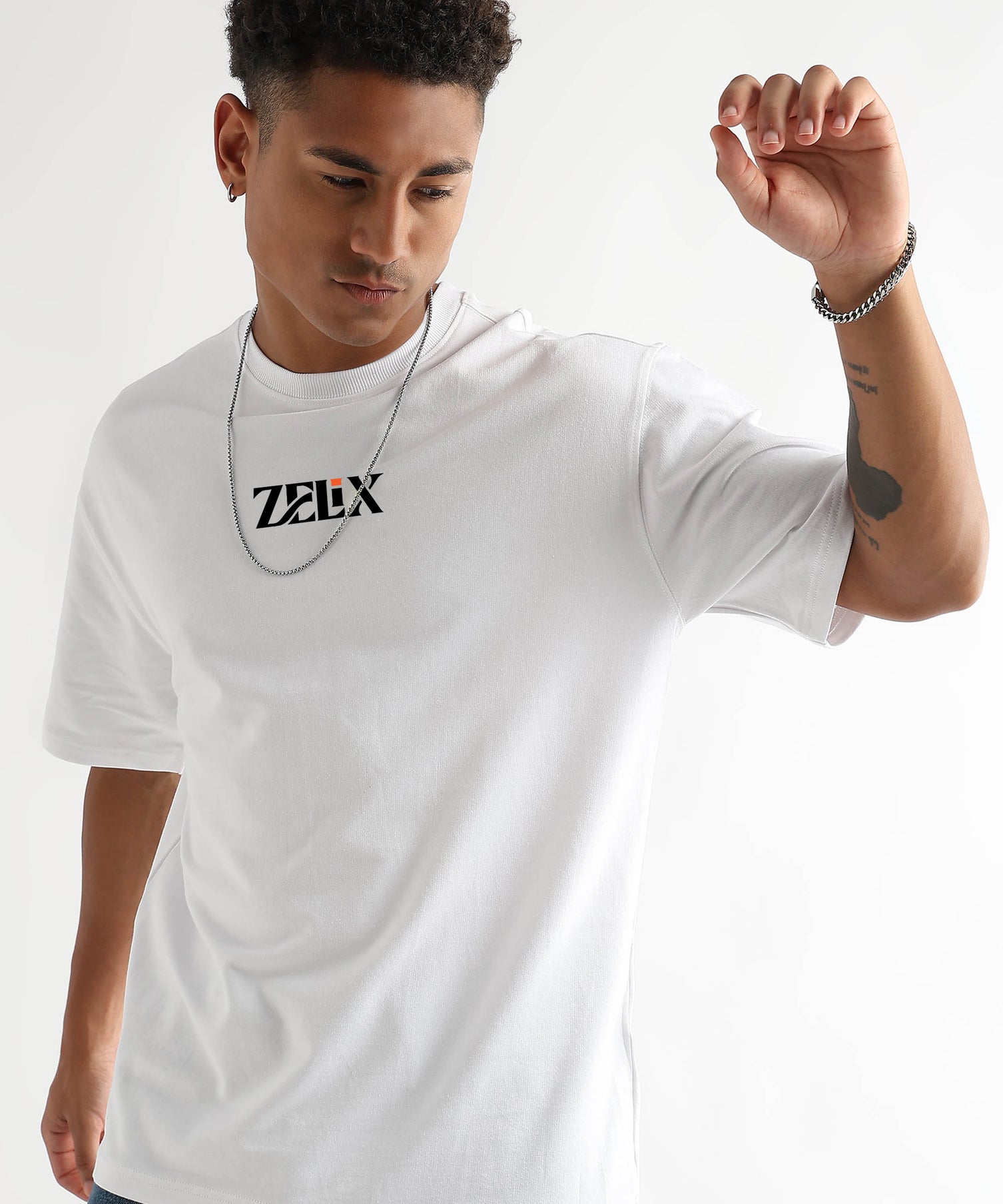 Man wearing a white t-shirt with 'Zelix' logo on a plain background