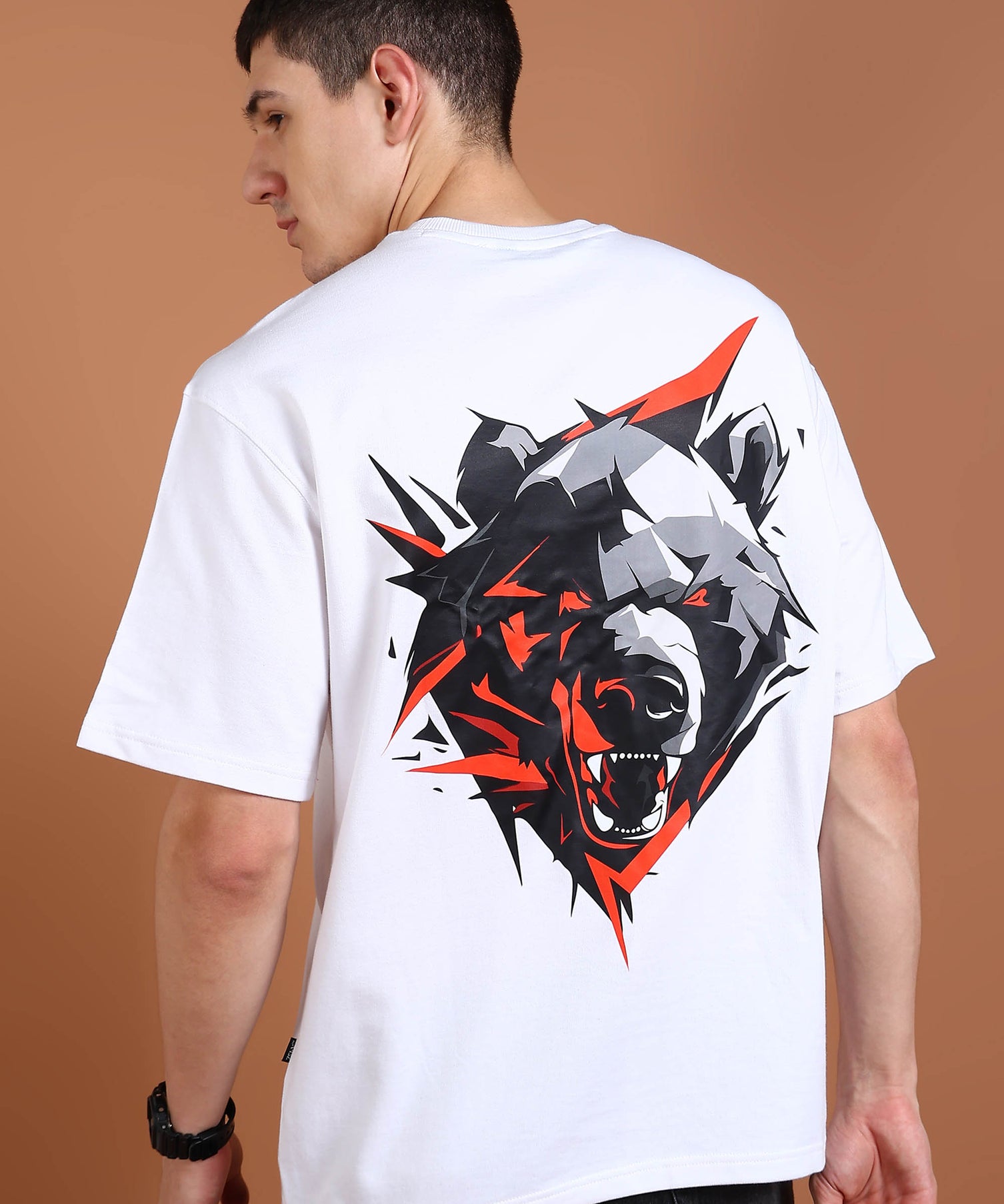 A person wearing a white oversized t-shirt with a geometric bear graphic on the back.