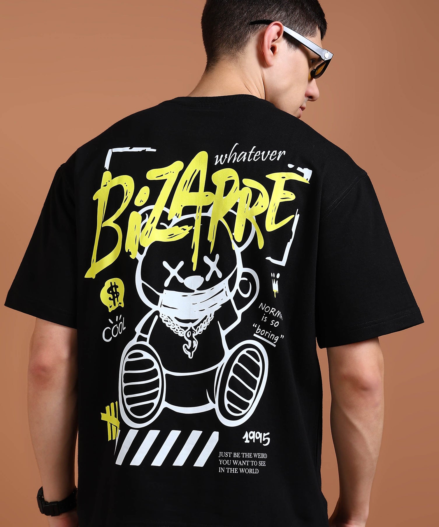 A person wearing an oversized black t-shirt with a graphic print of a bear and text on the back.