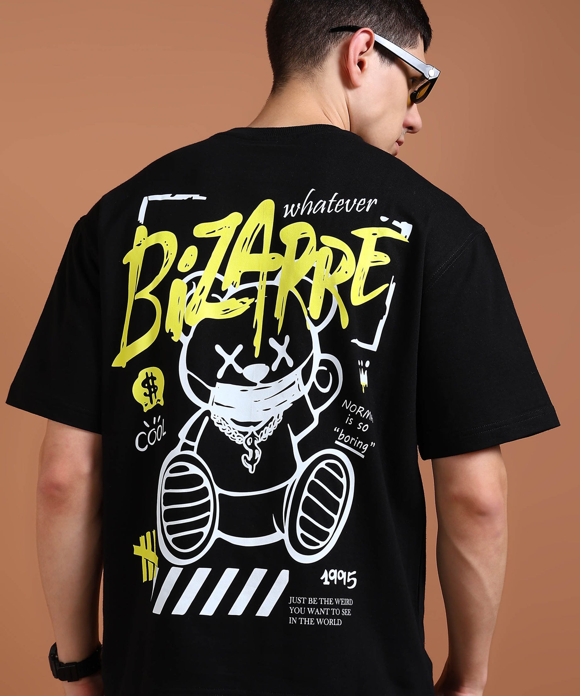 A person wearing an oversized black t-shirt with a graphic print of a bear and text on the back.