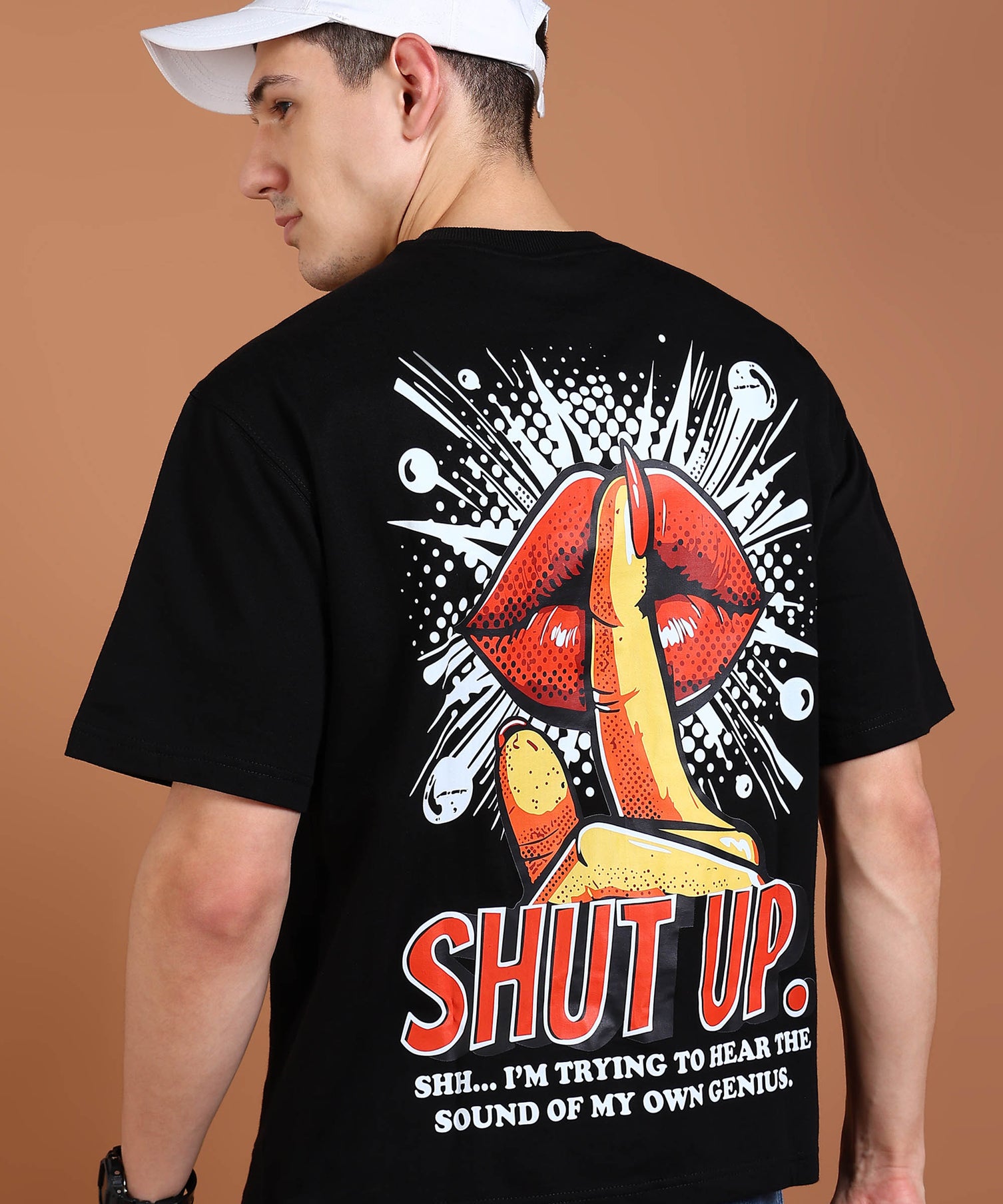 A person wearing a black oversized t-shirt with a graphic print on the back showcasing red lips and the text 'SHUT UP. I'm trying to hear the sound of my own sense.