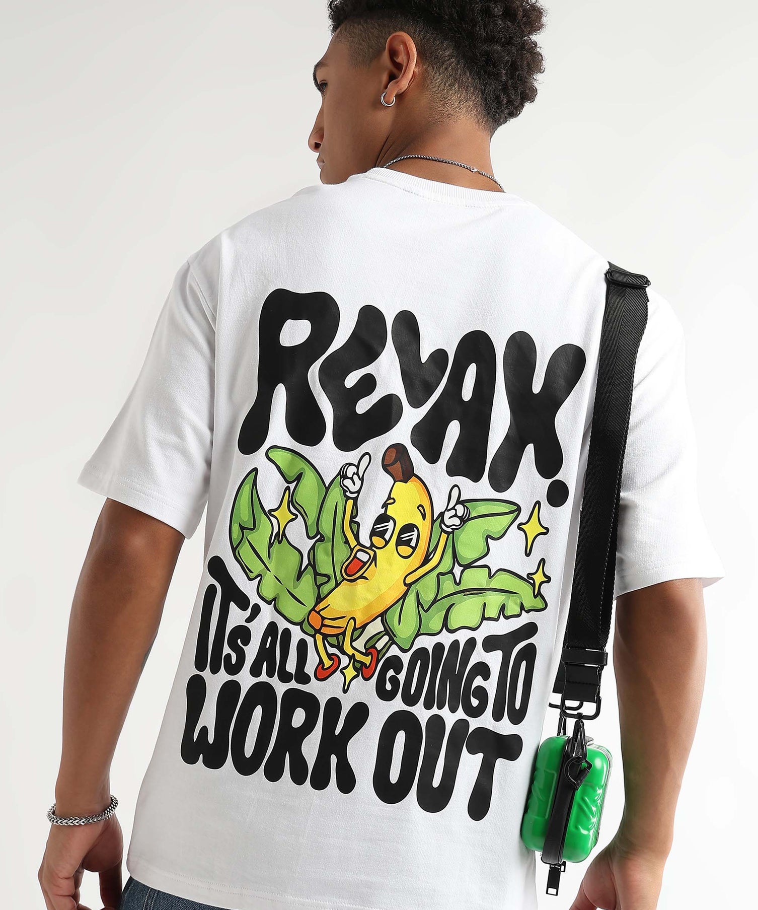 A person wearing a white oversized t-shirt with a banana graphic and text on the back.
