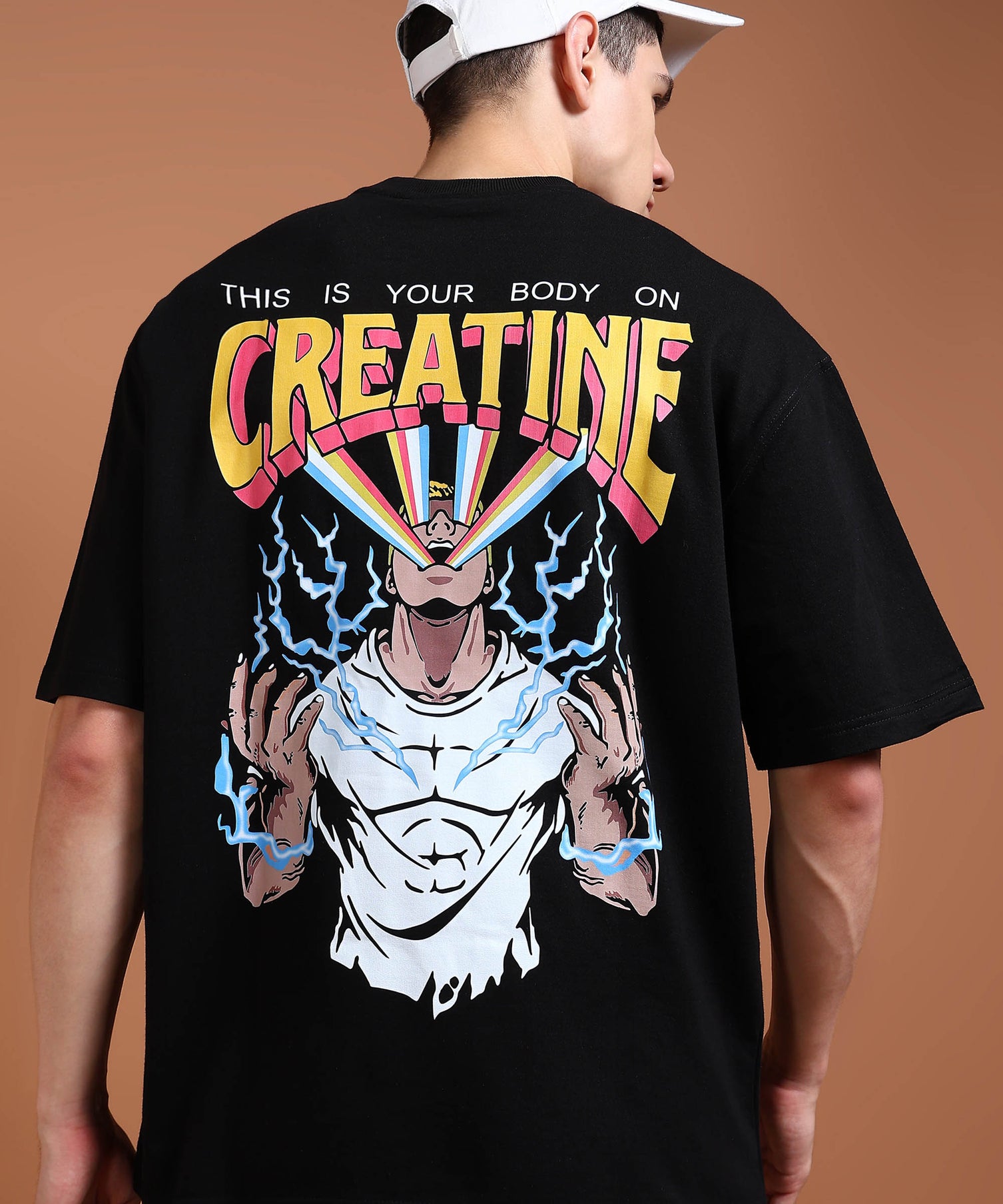A person wearing an oversized black t-shirt with a graphic print on the back depicting a muscular character and the text 'CREATINE'.