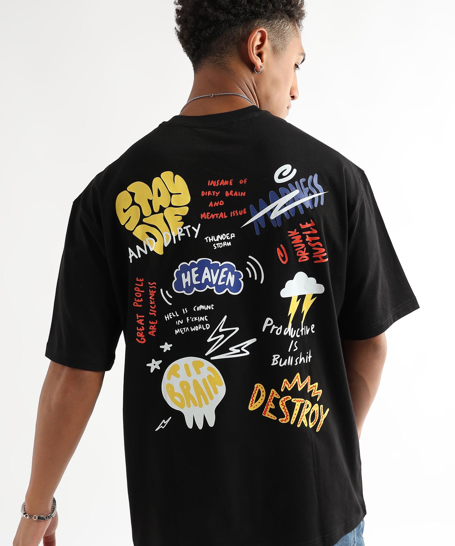 A person wearing an oversized black t-shirt with colorful text and graphic prints on the back.